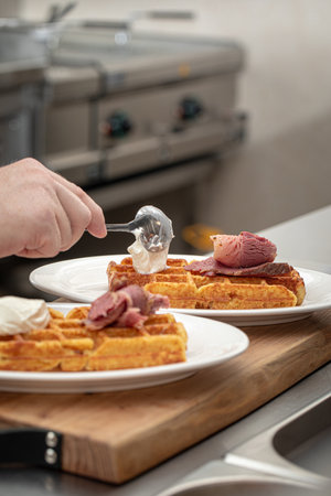 Chef puts cottage cheese on waffle with brisketの写真素材