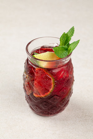 Glass of fresh berry tea with mint and iceの写真素材