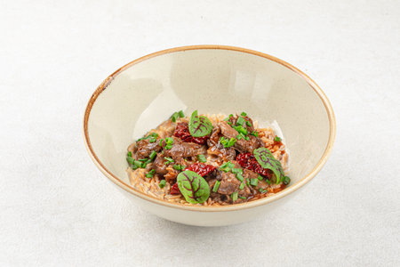 Portion of pasta orzo with meat and basilの写真素材