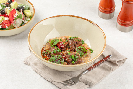Portion of pasta orzo with meat and basilの写真素材