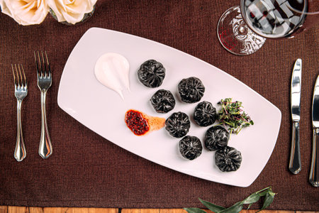 Gourmet black colored dumplings with sauceの写真素材