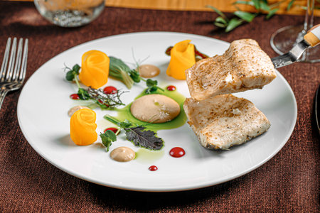 Portion of gourmet fish dish with fruit slicesの写真素材