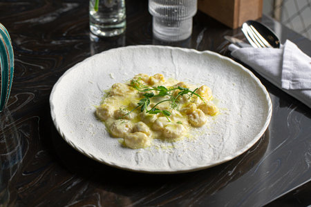 Portion of potato gnocchi with creamy sauceの写真素材