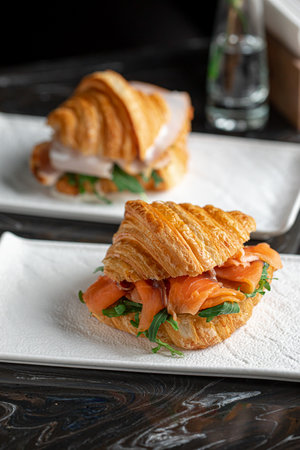 Croissant sandwich with salmon and arugulaの写真素材