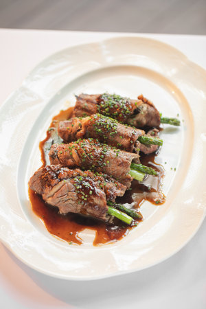 Portion of beef and asparagus rolls appetizerの写真素材