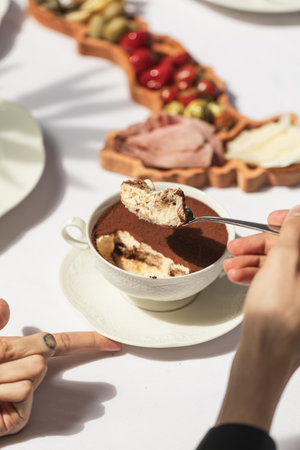 Eating tiramisu dessert in a bowlの写真素材
