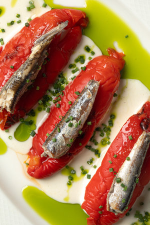 Portion of baked pepper appetizer with small fishの写真素材