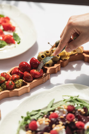 Eating marinated pepper delicacy from platterの写真素材