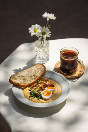 Portion of breakfast with hummus and eggs