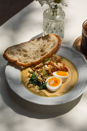 Portion of breakfast with hummus and eggs