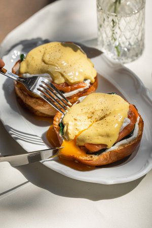 Eating eggs benedict with salmon on brioche bun
