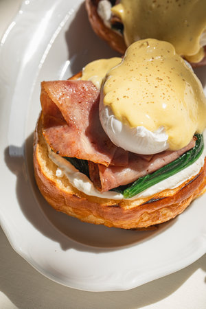 Portion of benedict eggs with sauce and brioche