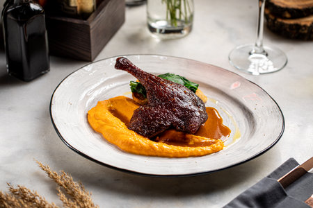 Roasted duck leg with puree on restaurant plateの写真素材