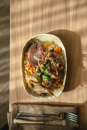 Plov with chicken and beef served in ceramic bowlの写真素材