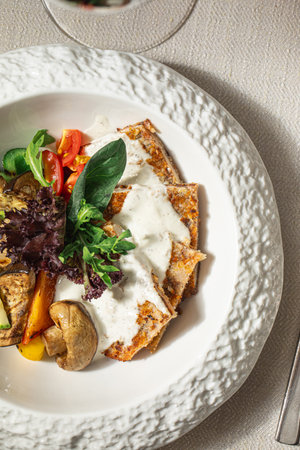 Schnitzel with white sauce and grilled vegetablesの写真素材