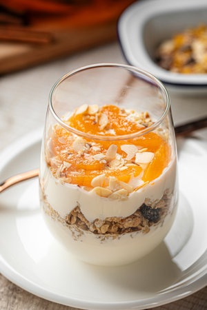 Yogurt dessert with granola and apricots in glass