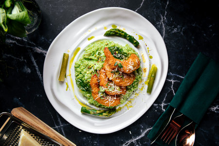 Green risotto with fried shrimp and asparagusの写真素材