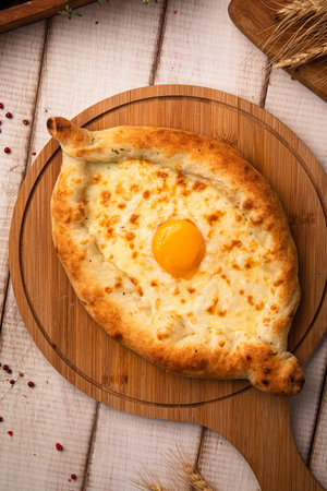Hot khachapuri with egg on wooden boardの写真素材