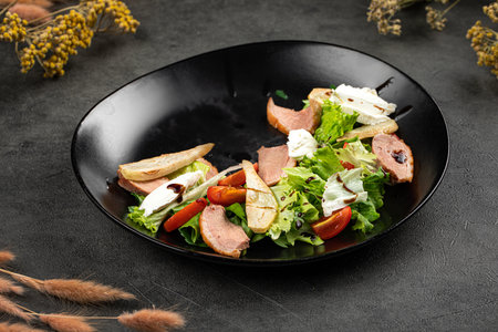 Duck salad with pear slices and mixed greensの写真素材