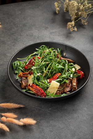 Fresh arugula salad with beef and sundried tomatoesの写真素材