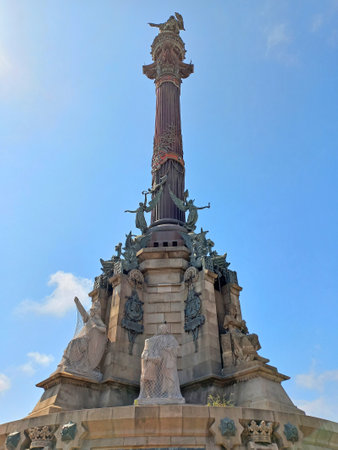 Barcelona Catalonia Spain. April 10 2025. Monument to Christopher Columbus with elaborate bronze column and lion statue near the waterfront at the end of La Rambla under sunny weatherの写真素材