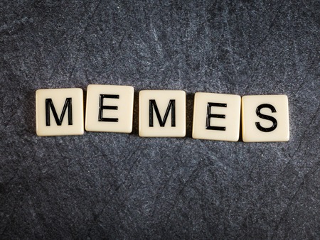 Letter tiles on black slate background spelling Memesの写真素材