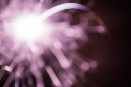 Defocused Firework sparkler burning on black backgroundの写真素材