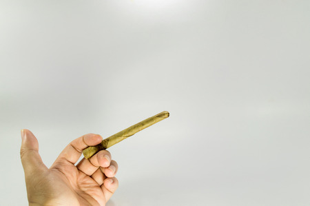 Hand holding a Native southeast asia cigarette.