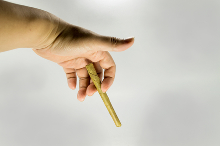 Hand holding a Native southeast asia cigarette.の写真素材
