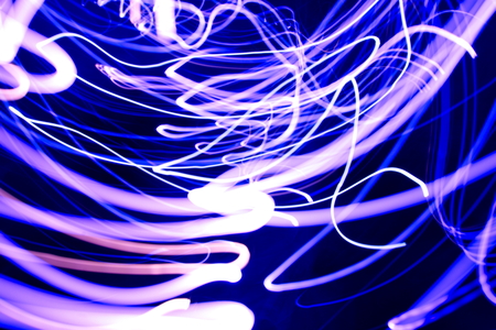 Abstract light painting photography, curves and waves abstract light against a black backgroundの写真素材