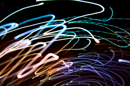 Abstract light painting photography, curves and waves abstract light against a black backgroundの写真素材