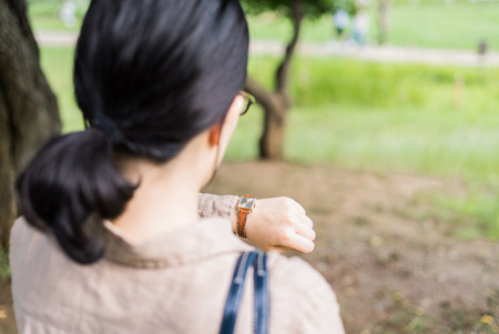 Asian woman looking at her watchの写真素材