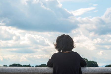 Asian woman looking at sky and lake
