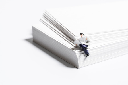 Businessman reading paper on the white paperの写真素材