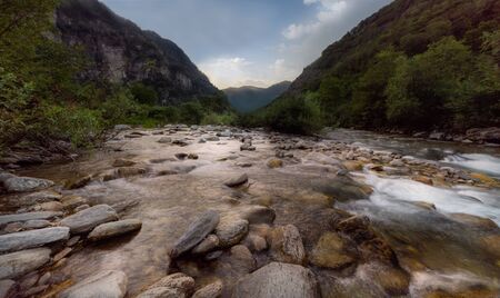 Long exposure Landscape in Lavorgo in Switzerland with rocks, river and mountains in the backgroundの写真素材