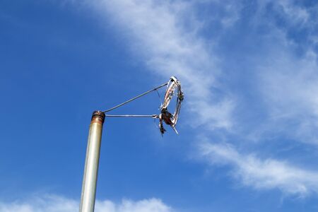 worn out windsock frame against blue sky