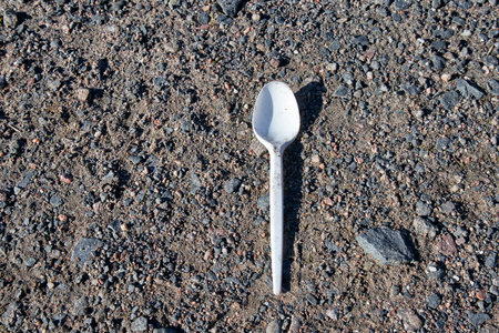 white plastic spoon on the groundの写真素材