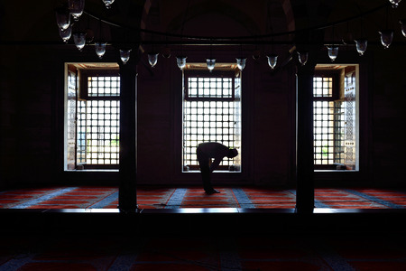 ISTANBUL, TURKEY - JULY 15  Suleymaniye mosque muslim prayers in front of the window, 15 July 2014 in Istanbul Turkey  The Suleymaniye Mosque is the largest mosque in the city, and one of the best-known sights of Istanbul  のeditorial素材