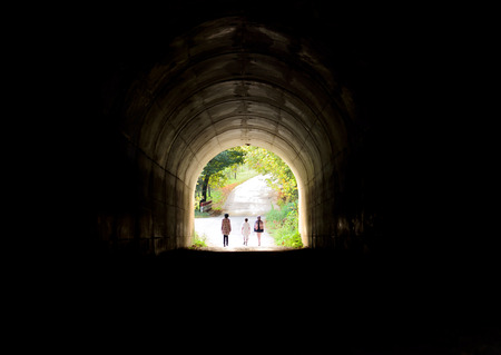 three teenagers on their way through the tunnel lightの写真素材