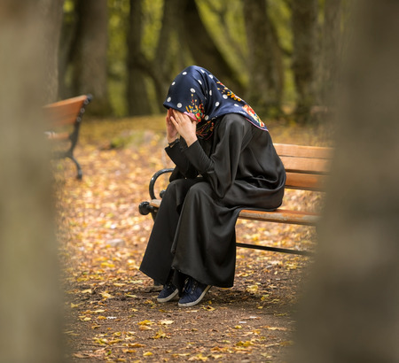 sad muslim woman sitting alone on the benchの写真素材