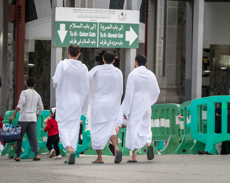 MECCA, SAUDI ARABIA - JAN 28: Muslim wearing ihram clothes and ready for Hajj on January 28, 2017 in Mecca, Saudi Arabia. Muslims in front of the grate to the door.のeditorial素材