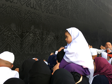 MECCA, SAUDI ARABIA - JANUARY 29: His father's shoulder girl who circumambulate in the Kaaba on January 29, 2017 in Mecca, Saudi Arabia. Muslim people praying together at holy place.のeditorial素材