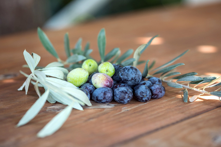 Olives on olive branch. Wooden table with olivesの写真素材