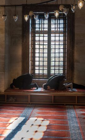 ISTANBUL, TURKEY - FEBRUARY 7: Suleymaniye mosque, young muslim prayer in front of the window, 7...