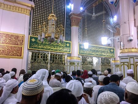 MEDINA, SAUDI ARABIA - JUNE 24, 2019: Unidentified Muslims worshiping in front of the tomb of the...