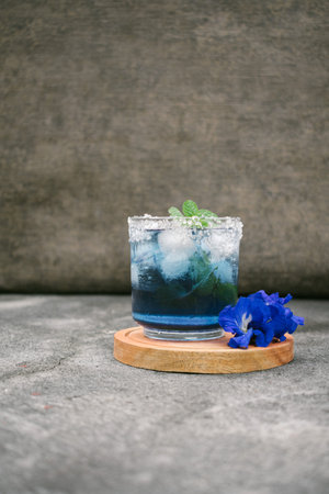 Blue tea Butterfly Pea Juice with ice in glass on concrete backgroundの写真素材