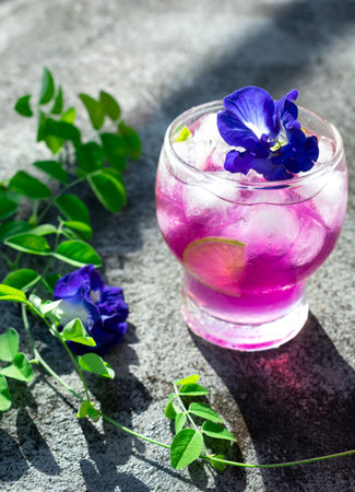 Butterfly pea juice with ice and flowers on concrete backgroundの写真素材