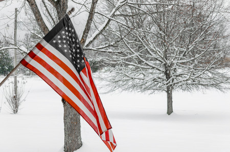 USA, American Flag with winter snow background. Celebrate National Holiday pride with red, white and...