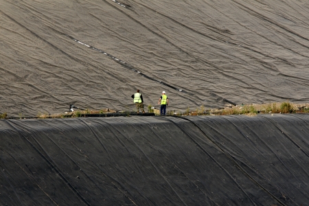Two engineers inspecting a landfill waste site