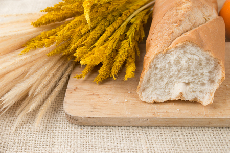 French bread baguettes on bread board and mandarin orangesの写真素材